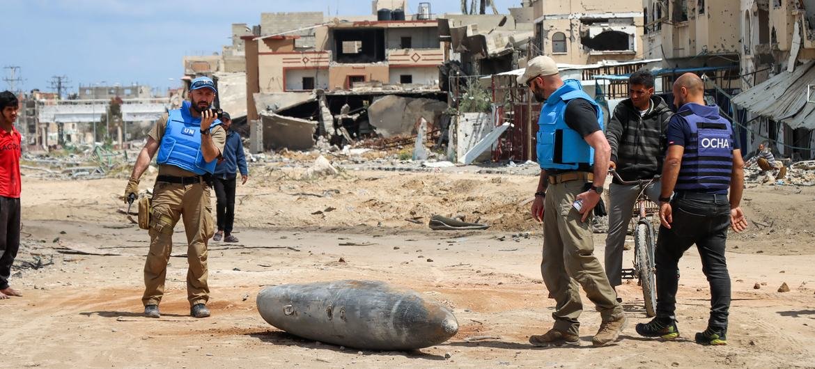 Uma equipe da ONU inspeciona uma bomba não detonada de 1 mil libras caída em uma estrada principal em Khan Younis Uma equipe da ONU inspeciona uma bomba não detonada de 1 mil libras caída em uma estrada principal em Khan Younis