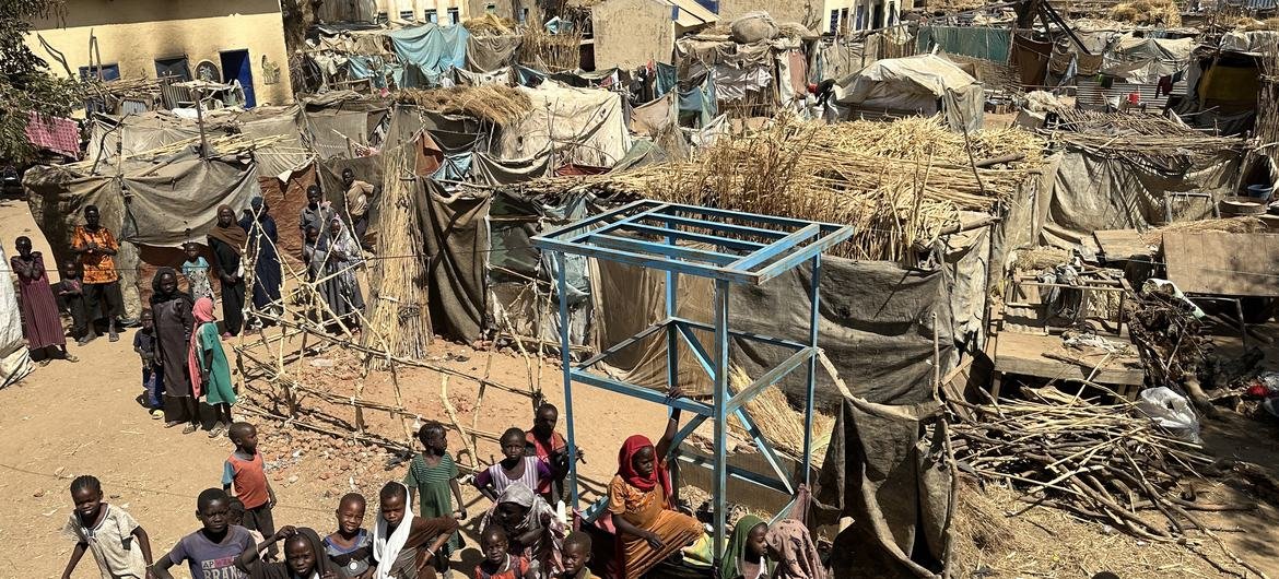 Uma vista aérea de crianças e suas famílias perto de abrigos temporários no local Khamsa Dagiga para pessoas deslocadas na cidade de Zelingei, Darfur Central, Sudão Uma vista aérea de crianças e suas famílias perto de abrigos temporários no local Khamsa Dagiga para pessoas deslocadas na cidade de Zelingei, Darfur Central, Sudão