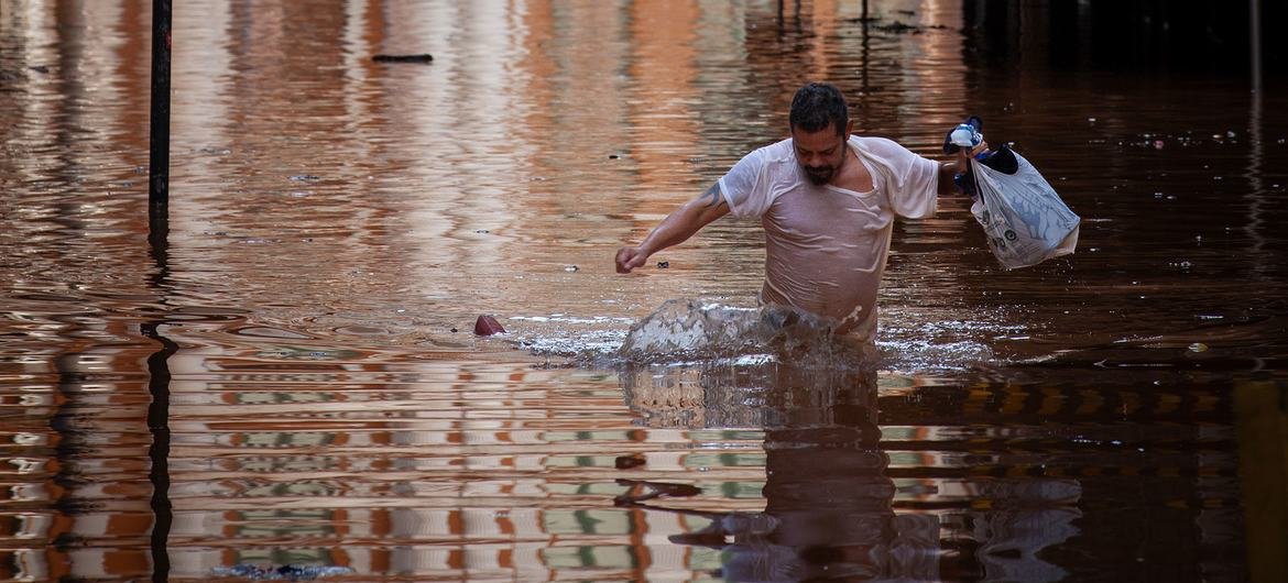 Um homem atravessa enchentes em Porto Alegre, Rio Grande do Sul, Brasil